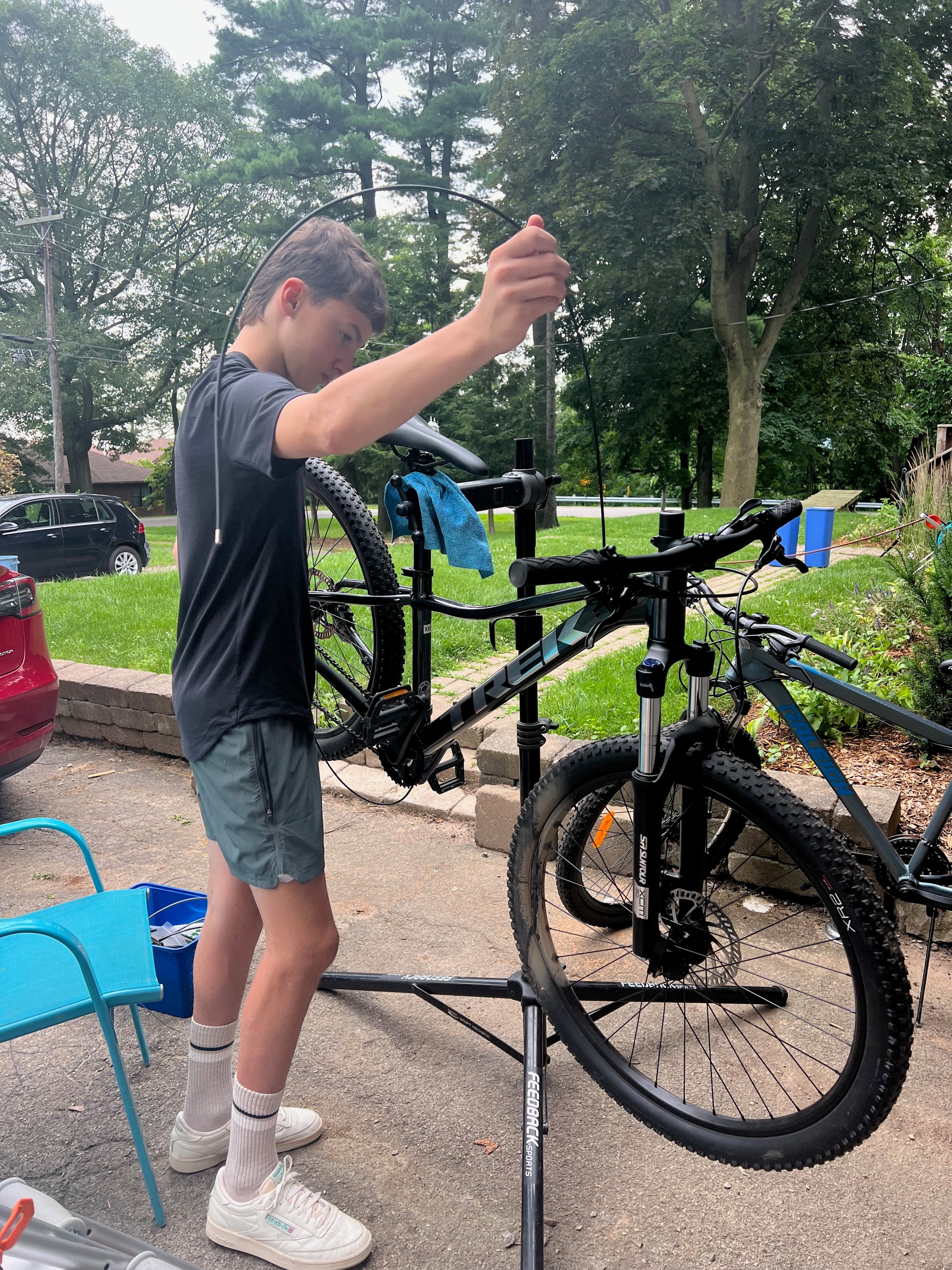 Asher performing bike maintenance on a repair stand outdoors
